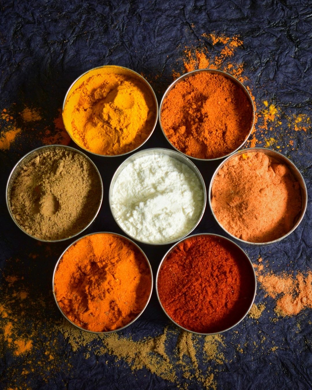 Traditional Eastern botanicals and ground spices in metal tins